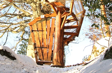 Cabane perchée dans les arbres Cantal Auvergne chemin enneigé